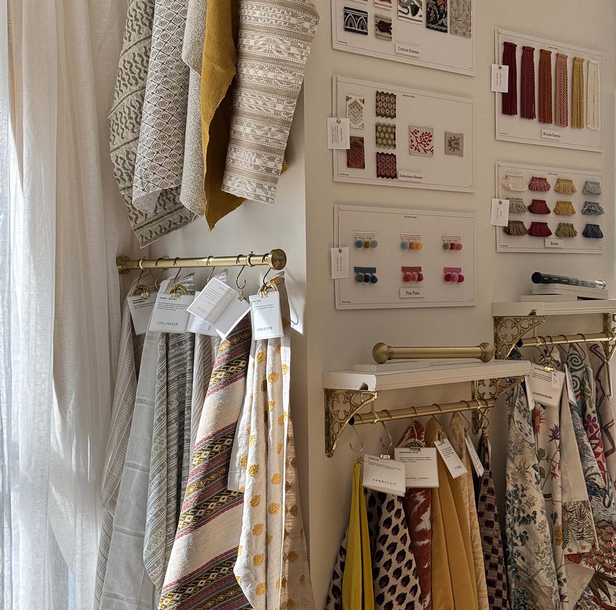 Fabric samples displayed on hangers with color swatches in a design studio.