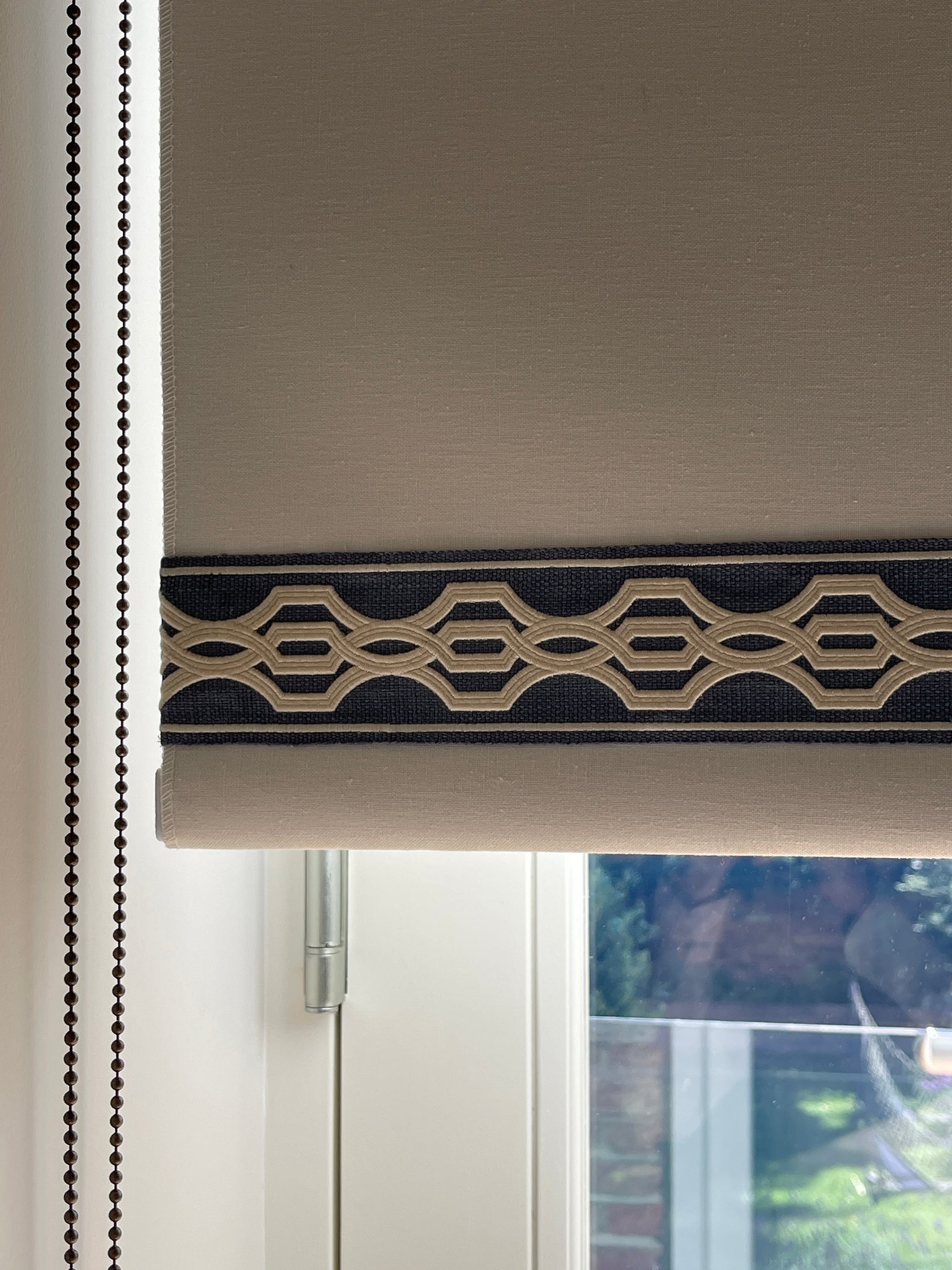 A window roller blind with striking border on the bottom edge