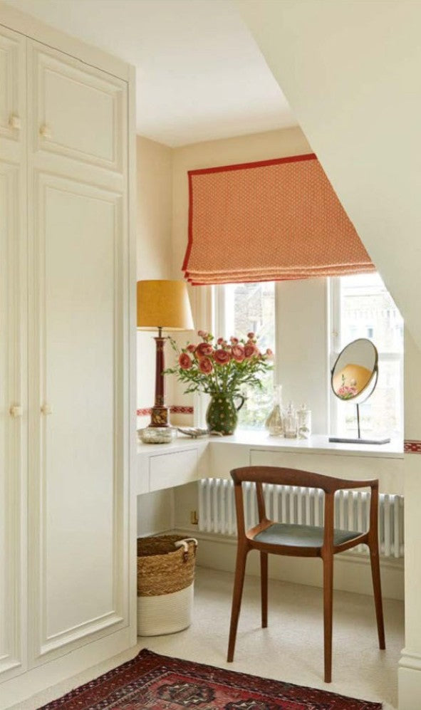 A small dressing nook featuring a thick interlined roman blind with striking orange border