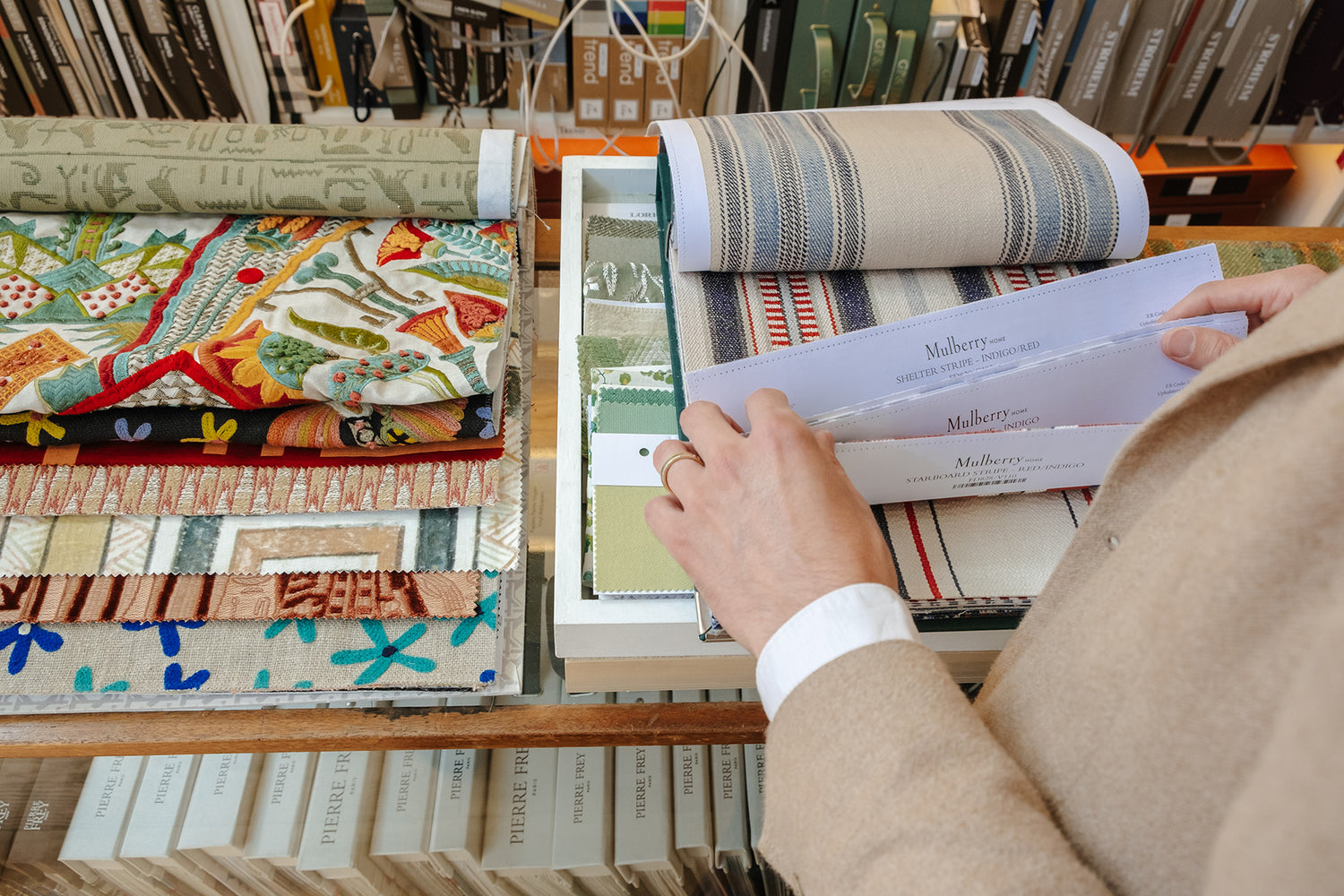 Max selecting fabric swatches from a display with a focus on texture and colour.