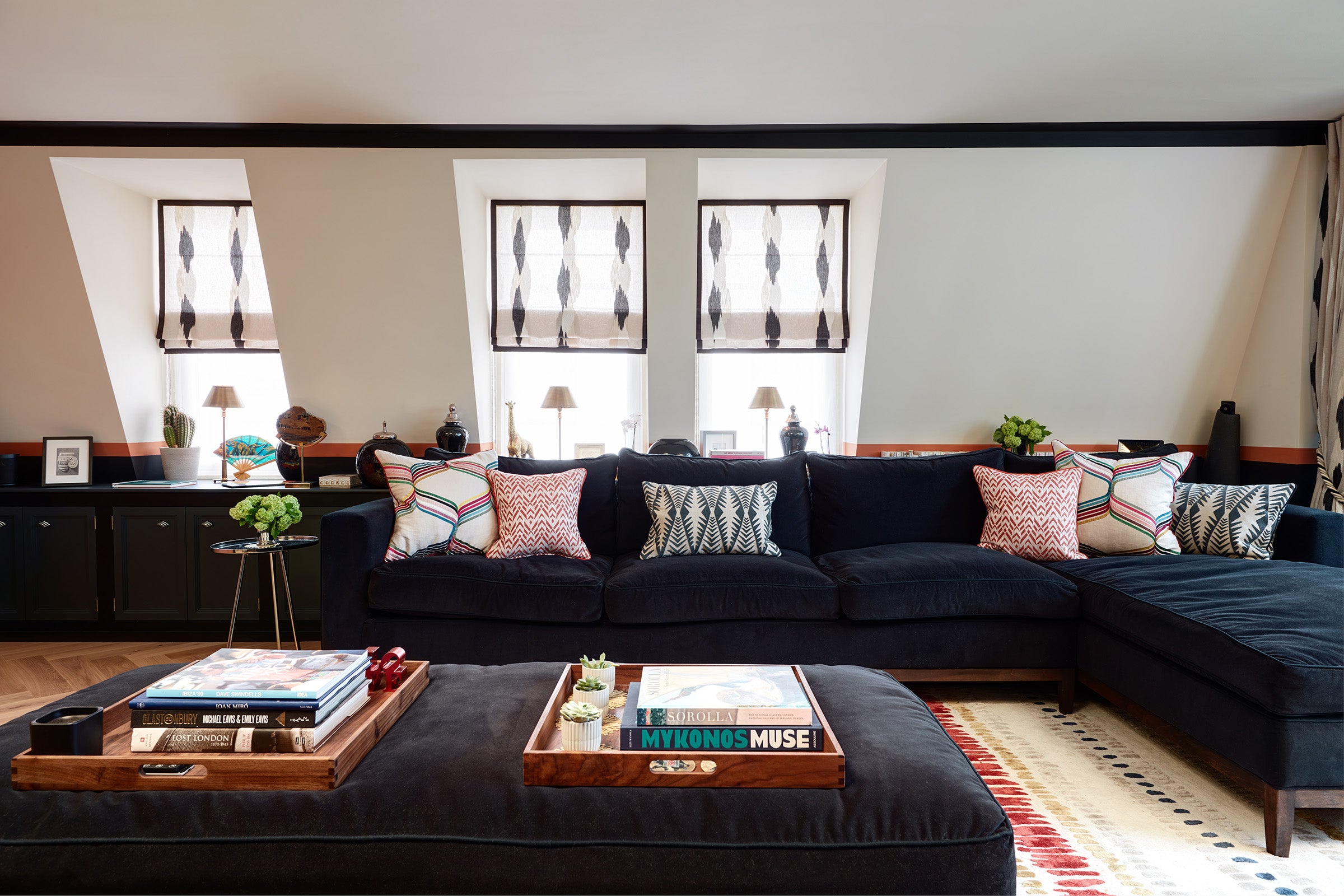 Modern living room with black and white sheer roman blinds in window recesses on mansard wall