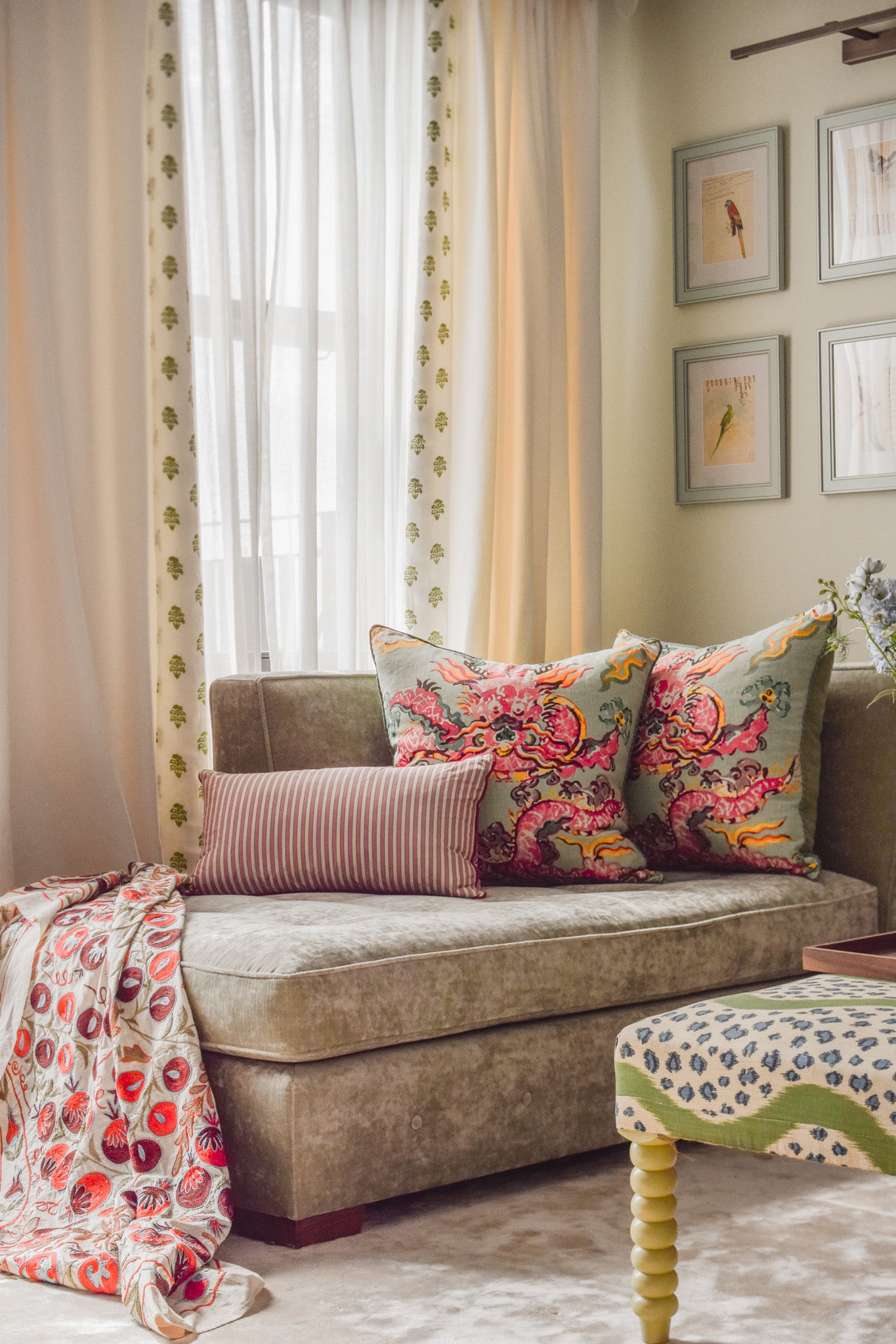 Neutral layered sheer curtains with C&C Milano border, with colourful cushions by Max Buston